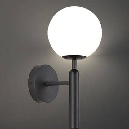 Modern LED-vägglampa med glaskula och cylindrisk stödlampa