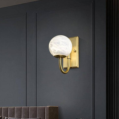 Designer LED vägglampa med rundad guldstav och vit lyxkula